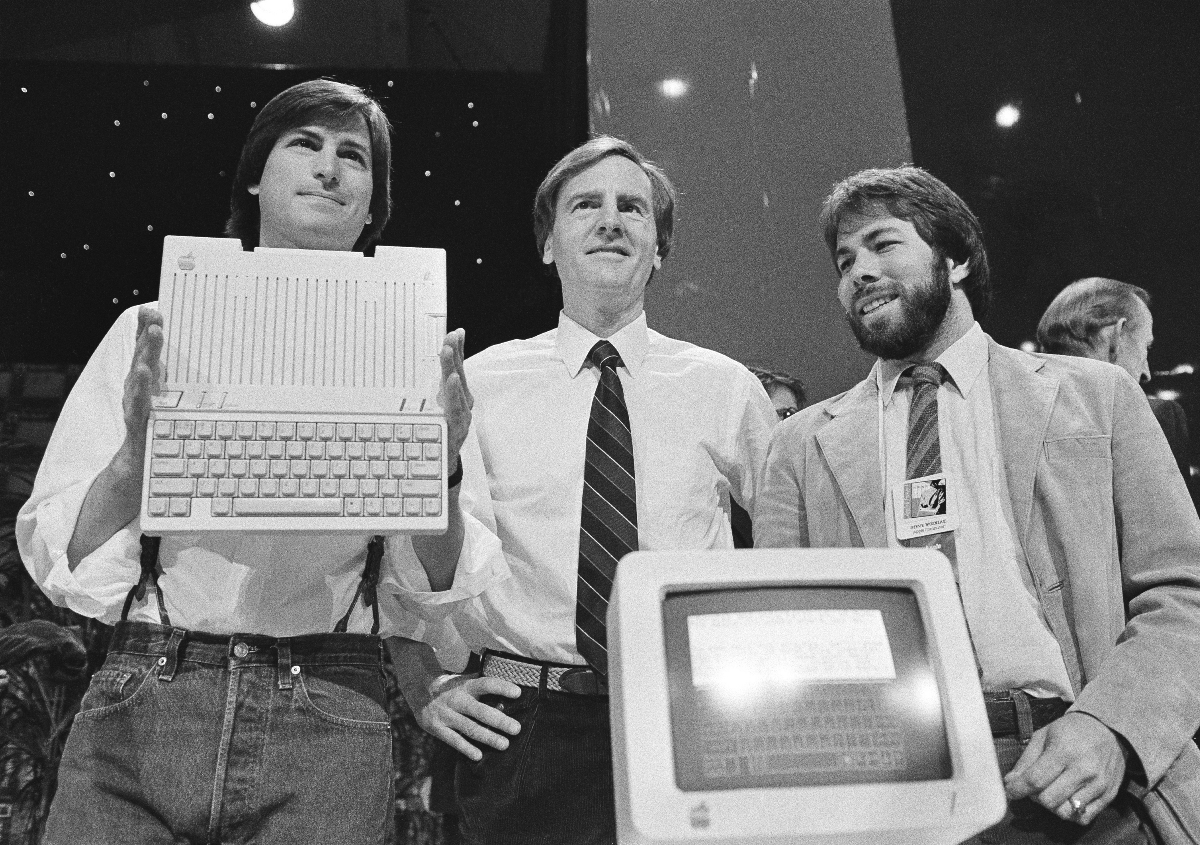 1984: Steve Jobs, John Sculley und Steve Wozniak präsentieren den neuen Apple IIc computer in San Francisco. (AP Photo/Sal Veder, File)