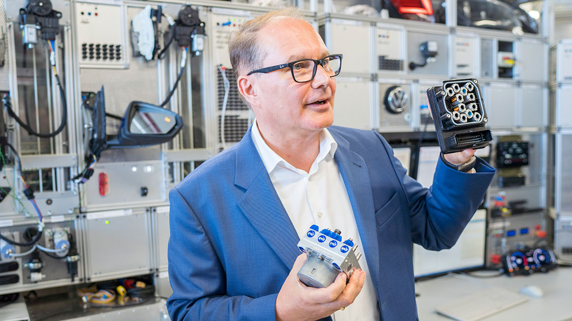 Entwicklungschef für Elektronik- und Elektrik Dr. Rolf Zöller zeigt ein Bauteil in der EE-Entwicklung. (Foto: Volkswagen)